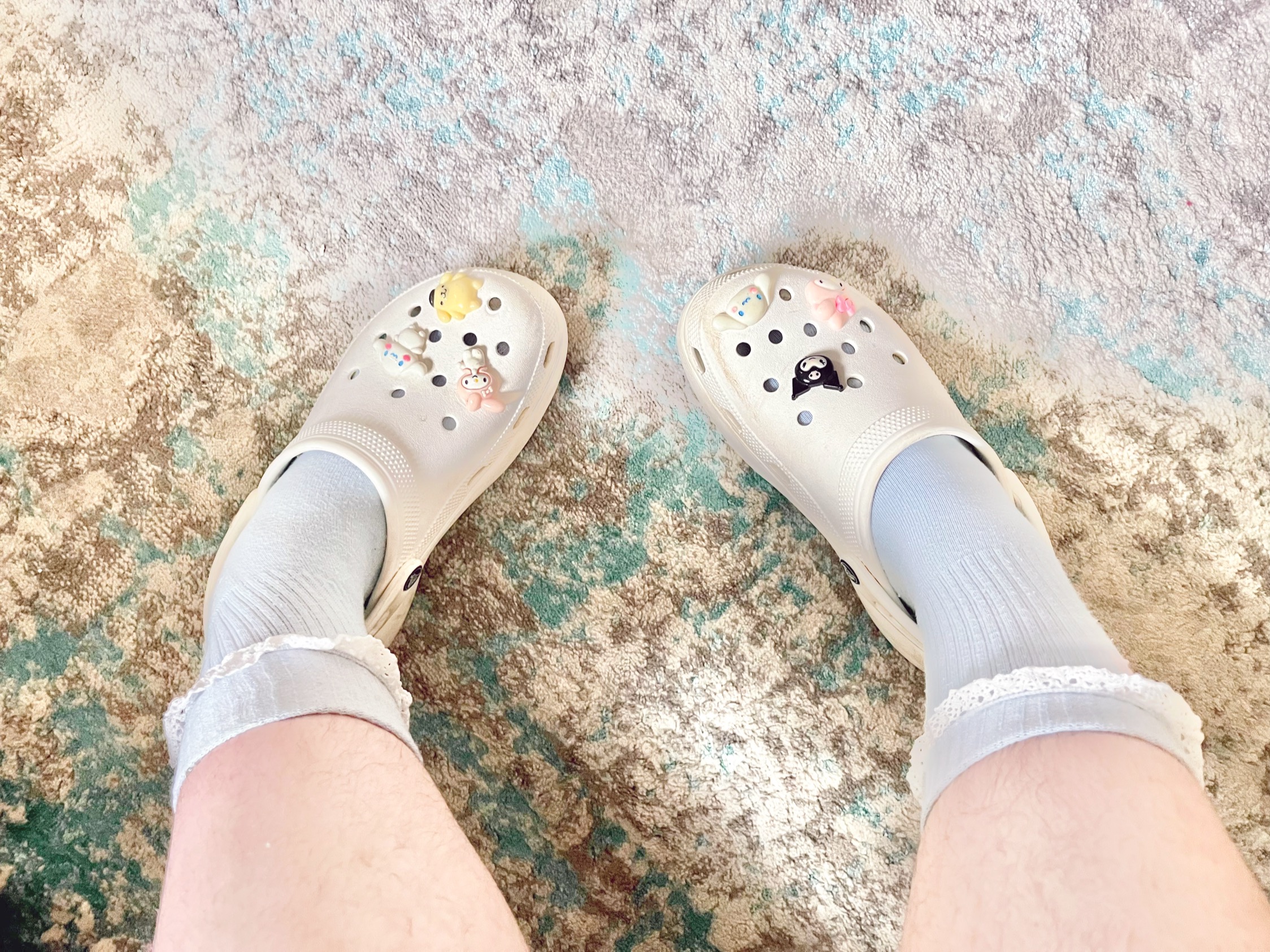 white platform croc shoes with sanrio charms on them