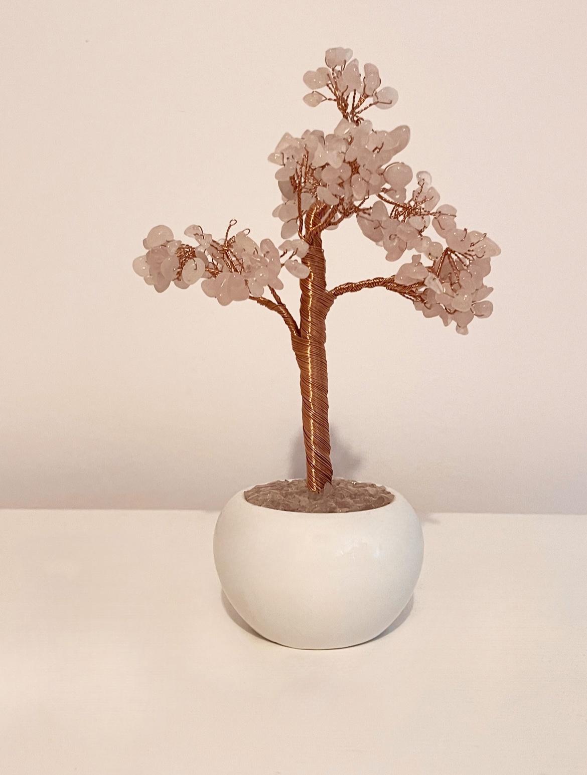a miniture tree made out of rose quartz crystals and wire