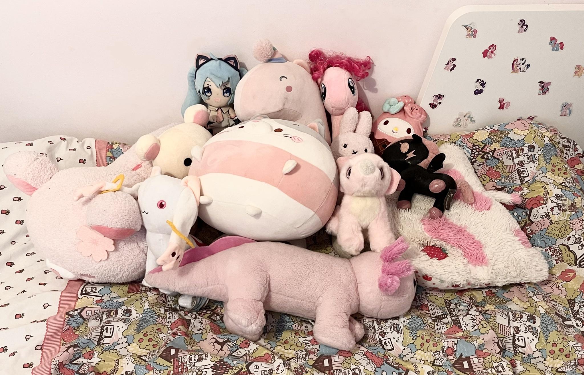lots of different plushies on a bed